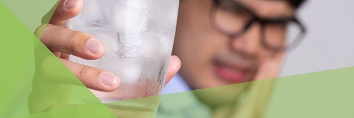 man with sensitive teeth and holding glass of cold water with ice.jpeg man with sensitive teeth and holding glass of cold water with ice.jpeg